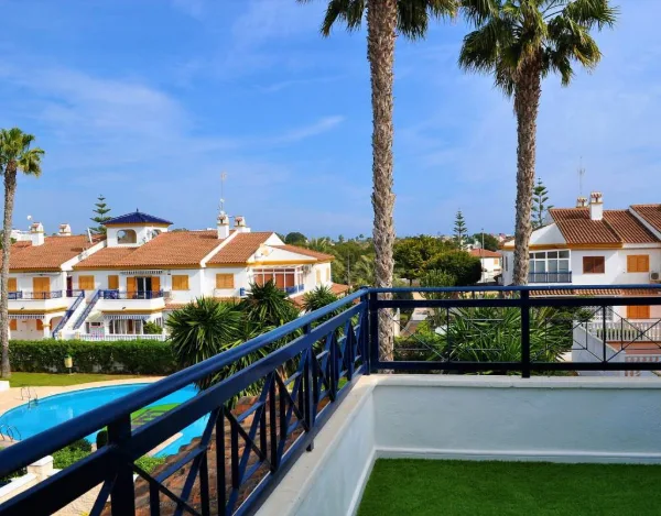 Blick vom Balkon über das Geländer auf den blauen Gemeinschaftspool